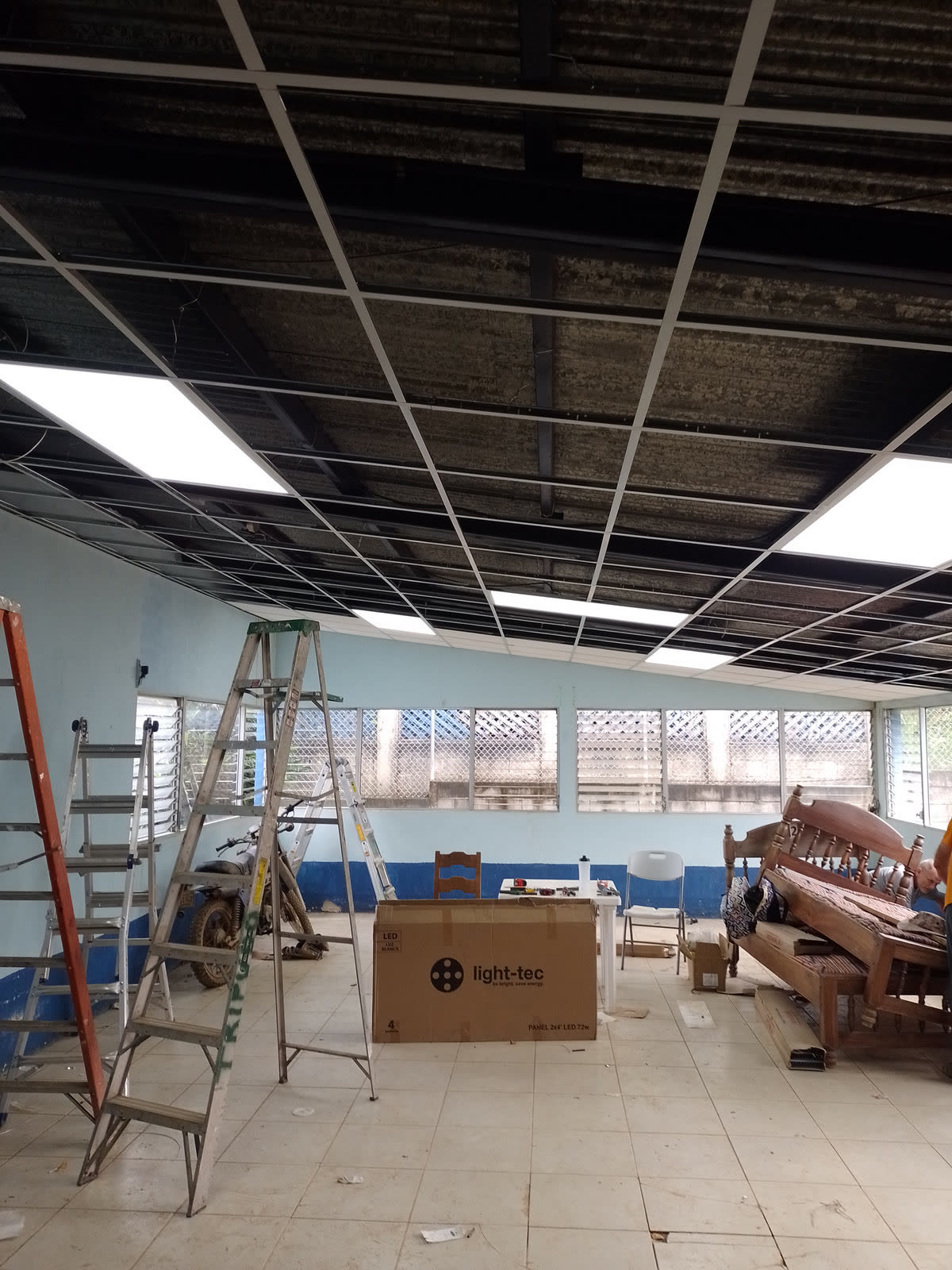 A clinic room under renovation with a ladder and new ceiling panels