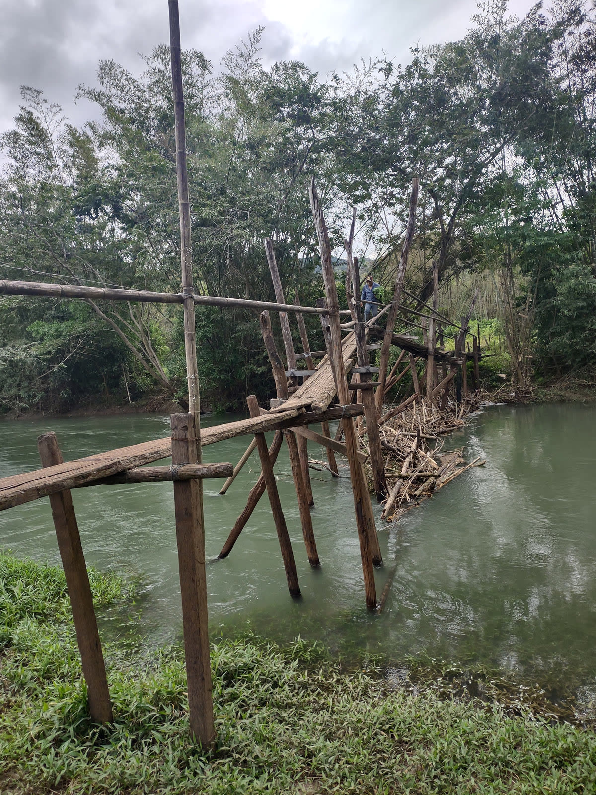 A damaged wooden footbridge over a river