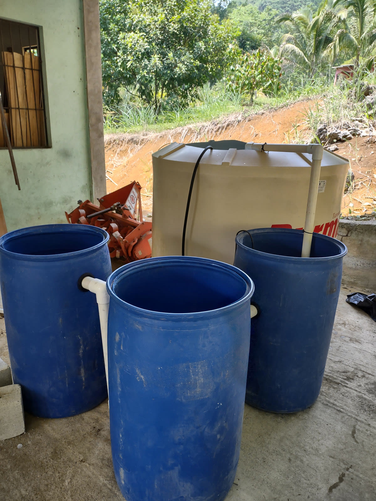 Blue water barrels and a storage tank under a roof