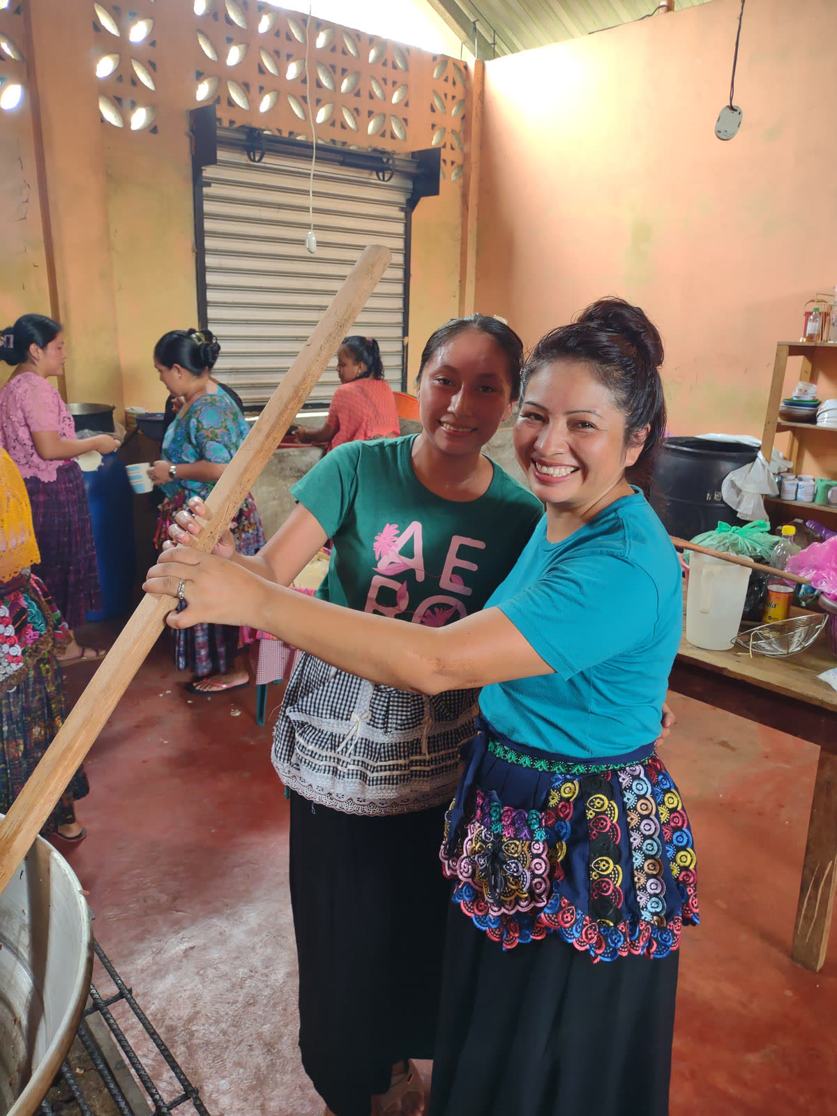 Two women embrace in a kitchen