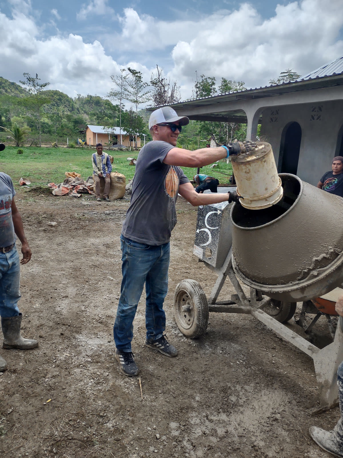A man operates a cement mixer at a construction site