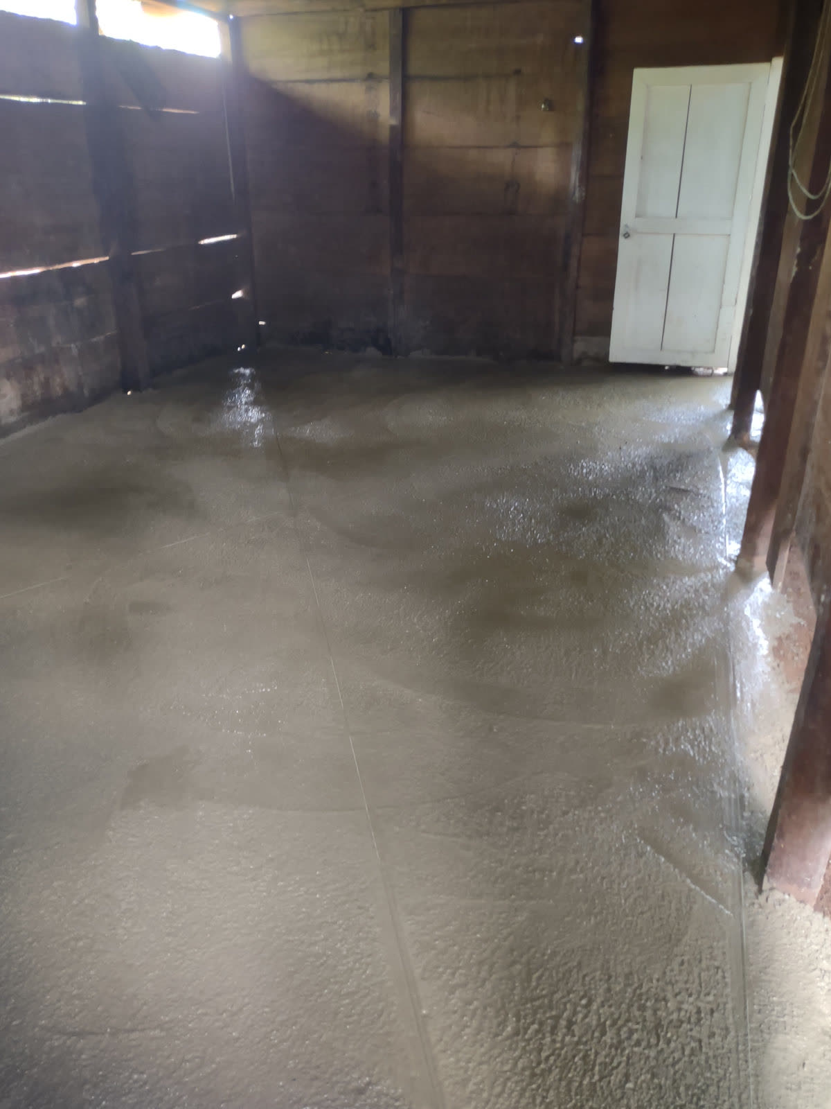A freshly poured concrete floor inside a wooden house