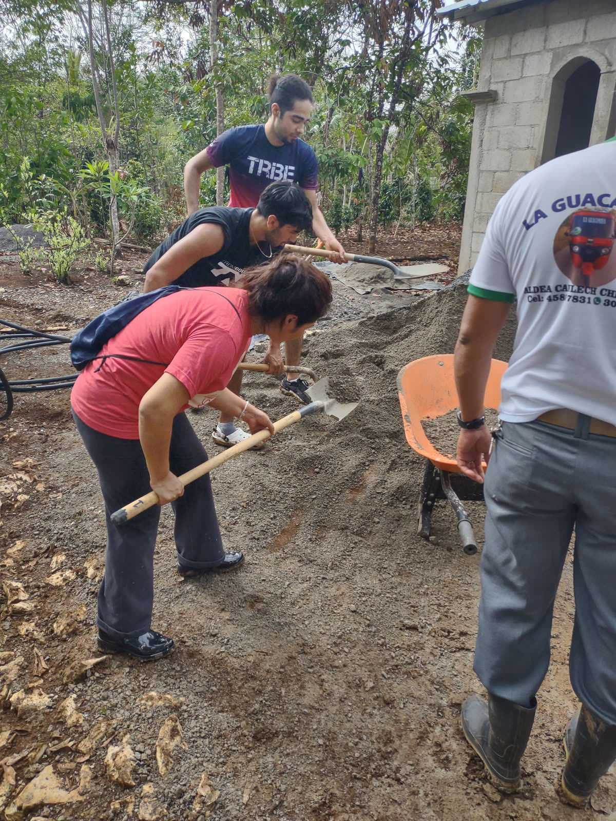 Volunteers shovel sand at a work site