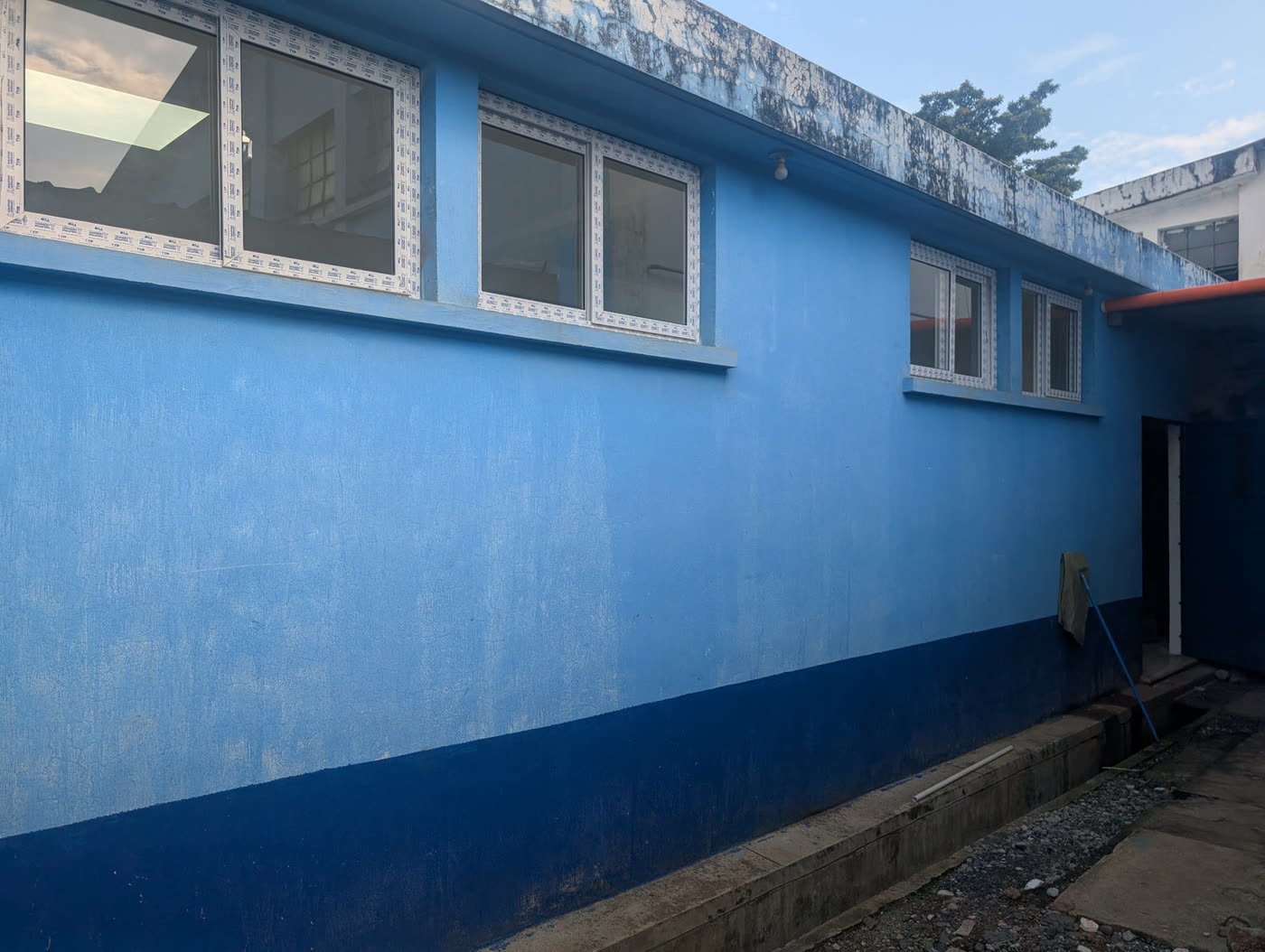 Exterior wall of a clinic building freshly painted blue