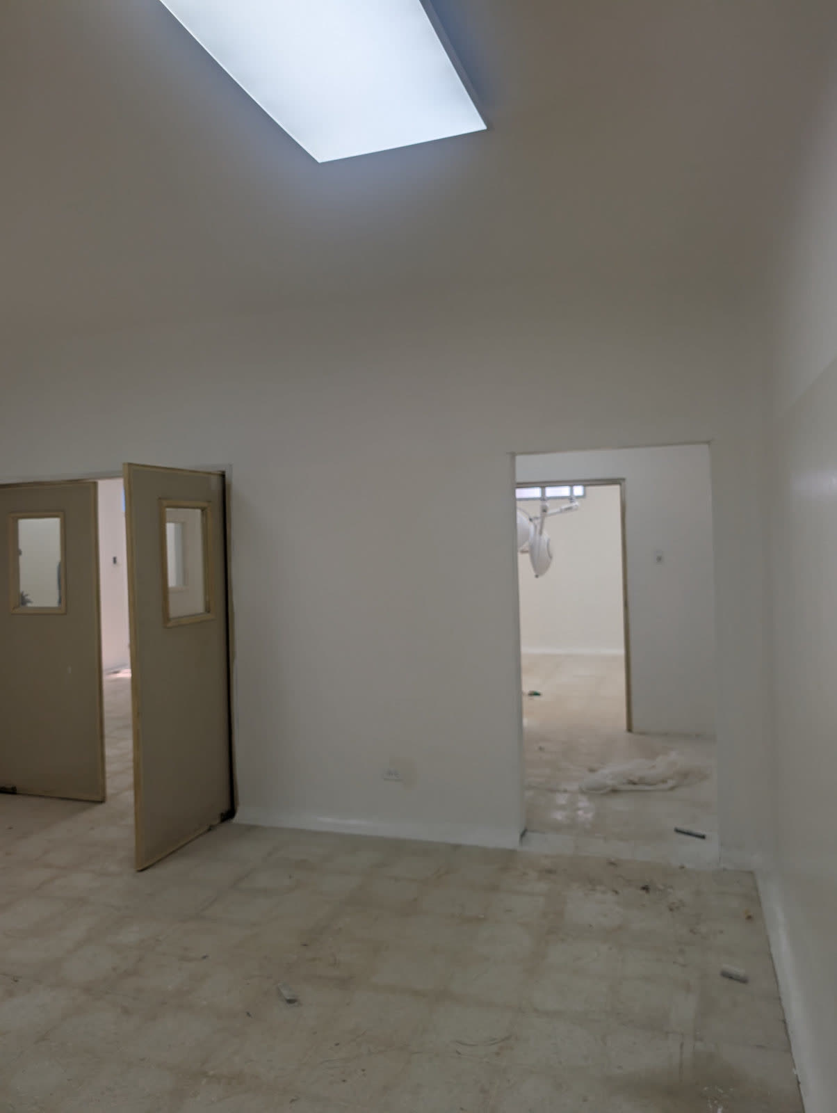 A newly finished clinic room with white walls and a tiled floor